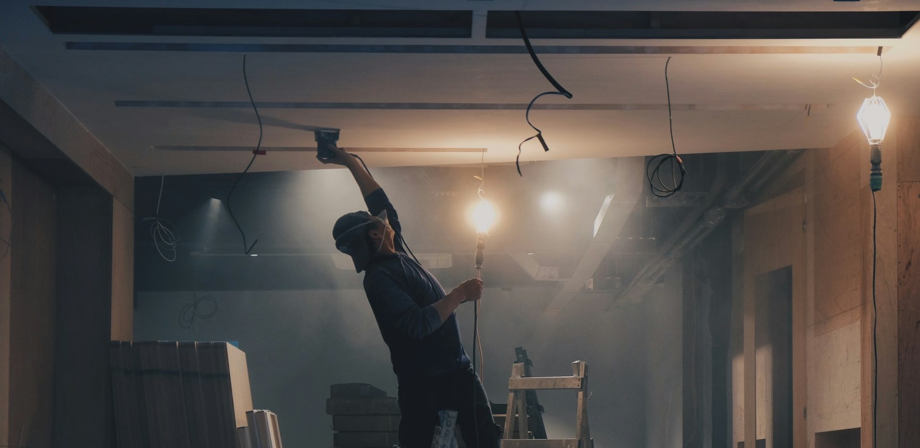 artisan réalisant l'isolation en sous face d'un plancher bas